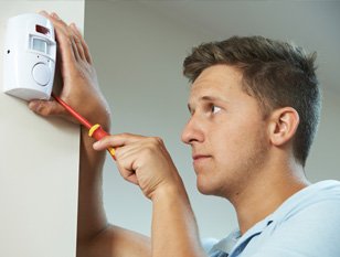 Engineer fitting an alarm motion sensor